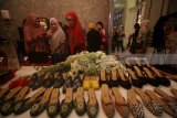 Pengunjung melihat produk sepatu rancangan Novita Yunus saat acara Batik Chic Roadshow 2018 di Surabaya, Jawa Timur, Selasa (17/4). Kegiatan yang dimeriahkan dengan rangkaian acara peragaan busana tunggal, pameran foto dan produk batik rancangan Novita Yunus tersebut dalam rangka memperingati Hari Kartini 2018. Antara Jatim/Moch Asim/zk/18