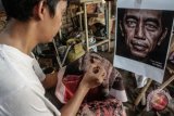 Perajin batik, Tamakun, memproduksi batik bergambar Presiden Joko Widodo di Pekalongan, Jawa Tengah, Kamis (19/4/2018). Menurut perajin tersebut, batik bergambar Presiden Joko Widodo tersebut yang diproduksi dengan cara dibatik realis tersebut akan digunakan sebagai buah tangan untuk Presiden Joko Widodo saat menghadiri acara penghargaan Inacraft 2018 pada 25-29 April mendatang di Jakarta. (ANTARA FOTO/Harviyan Perdana Putra)