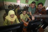 Anggota Komisi X DPR Anang Hermansyah (kedua kanan) didampingi Kepala Dinas Pendidikan Kota Surabaya Ikhsan (kanan) melihat contoh soal ujian pada layar komputer saat berkunjung ke SMP Negeri 3, Surabaya, Jawa Timur, Kamis (5/4). Kunjungan tersebut guna mamantau persiapan pelaksanaan Ujian Nasional Berbasis Komputer (UNBK) untuk jenjang SMP/MTs yang akan diselenggarakan pada 23-26 April 2018. Antara jatim/Moch Asim/zk/18