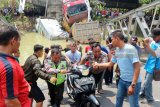 Sejumlah petugas mengevakuasi sepeda motor yang tercebur dalam kejadian jembatan Widang, di Kecamatan Widang, Tuban, Jawa Timur,  bagian barat yang ambrol sepanjang lebih dari 50 meter, Selasa (17/4) sekitar pukul 10.15 WIB. Dalam kejadian itu satu pengemudi truk ditemukan meninggal dunia, tiga korban selamat, serta tiga truk dan sebuah sepeda motor masuk ke Bengawan Solo. Antara Jatim/Aguk Sudarmojo/zk/18.