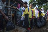 Sejumlah siswa antri untuk menukarkan sampah plastik dengan voucher saat Festival Citarum di Kampung Babakan Cianjur, Desa Cihampelas, Kabupaten Bandung Barat, Sabtu (28/4). Festival tahunan tersebut ditujukan untuk menanamkan kesadaran untuk menjaga kebersihan lingkungan kepada anak sejak dini. ANTARA JABAR/Raisan Al Farisi/agr/18