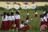 Sejumlah siswa SD membaca buku bersama di pematang sawah di kawasan Kadipiro, Solo, Jawa Tengah, Senin (23/4/2018). Kegiatan yang digelar untuk memperingati Hari Buku Sedunia tersebut bertujuan untuk mendekatkan siswa dengan alam. (ANTARA/Maulana Surya) 