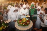 Ketua Umum Muslimat NU Khofifah Indar Parawansa (tengah) memotong tumpeng di sela acara peringatan Hari Lahir (Harlah) ke-72 Muslimat NU di Surabaya, Jawa Timur, Rabu (18/4). Dalam kegiatan yang dihadiri ribuan muslimat dari berbagai cabang hingga ranting di Jawa Timur tersebut Khofifah berharap keberadaan Muslimat NU terus konsisten memberikan kebaikan dan keberkahan bagi bangsa. Antara Jatim/Moch Asim/zk/18