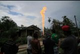 Warga menyaksikan semburan api di lokasi pengeboran minyak illegal yang dikelola warga di kawasan Dusun Kamar Dingin Desa Pasir Putih, Ranto Panjang Peureulak, Kabupaten Aceh Timur, Aceh, Rabu (25/4). Terbakarnya sumur minyak Ilegal itu mengakibatkan sebanyak puluhan orang terluka dan sekitar 10 orang meninggal dunia. ANTARA FOTO/Rahmad/kye/18.