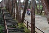 Pengendara sepeda motor melintas di atas jembatan lama Kertosono yang konstruksinya telah miring di Kertosono, Nganjuk, Jawa Timur, Selasa (3/4). Jembatan peninggalan Belanda penghubung Kabupaten Nganjuk dengan Kabupaten Kediri itu dibuka paksa oleh warga setelah sebulannya ditutup total dan dipasang garis polisi karena hampir roboh. Antara jatim/Prasetia Fauzani/zk/18