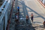 Sejumlah pekerja mengempur  jembatan Widang yang ambruk di Kecamatan Widang, Tuban, Jawa Timur, yang masih menyisakan satu truk di Bengawan Solo, Jumat (20/4). Jembatan Widang yang ambruk itu, akan diperbaiki dengan memanfaatkan jembatan 'bally' dengan target sudah bisa dimanfaatkan sebelum Hari Raya Idul Fitri. Antara Jatim/Aguk Sudarmojo/zk/18.