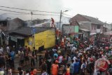 Petugas pemadam kebakaran mencoba memadamkan api yang membakar permukiman penduduk di kawasan Sumur Batu, Jakarta, Jumat (20/4/2018). Kebakaran yang melanda permukiman penduduk dan kios itu diduga disebabkan korsleting listrik. (ANTARA FOTO/Muhammad Adimaja) 