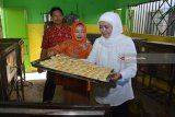 ANTARA FOTO/Umarul Faruq Calon Gubernur Jawa Timur, Khofifah Indar Parawansa (kanan) membawa kue pia yang sudah masak di industri rumahan Kampung Pia kawasan Gempol, Pasuruan, Jawa Timur, Jumat (20/4). Calon Gubernur Jawa Timur bernomor urut dua tersebut untuk mendengarkan secara langsung keluhan pelaku Usaha kecil terkait terkendala dengan masalah pemasaran yang harus bersaing dengan bakpia produksi pabrik dan permodalan serta dijadikannya kampung pia sebagai kampung wisata. Antara Jatim/Umarul Faruq/zk/18