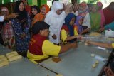 Calon Gubernur Jawa Timur, Khofifah Indar Parawansa (tengah) melihat proses pembuatan kue pia di industri rumahan Kampung Pia kawasan Gempol, Pasuruan, Jawa Timur, Jumat (20/4). Calon Gubernur Jawa Timur bernomor urut dua tersebut untuk mendengarkan secara langsung keluhan pelaku Usaha kecil terkait terkendala dengan masalah pemasaran yang harus bersaing dengan bakpia produksi pabrik dan permodalan serta dijadikannya kampung pia sebagai kampung wisata. Antara Jatim/Umarul Faruq/zk/18
