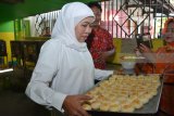 Calon Gubernur Jawa Timur, Khofifah Indar Parawansa membawa kue pia yang sudah masak di industri rumahan Kampung Pia kawasan Gempol, Pasuruan, Jawa Timur, Jumat (20/4). Calon Gubernur Jawa Timur bernomor urut dua tersebut untuk mendengarkan secara langsung keluhan pelaku Usaha kecil terkait terkendala dengan masalah pemasaran yang harus bersaing dengan bakpia produksi pabrik dan permodalan serta dijadikannya kampung pia sebagai kampung wisata. Antara Jatim/Umarul Faruq/zk/18
