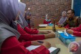 Menteri Ketenagakerjaan Hanif Dhakiri (kiri) berbincang dengan sejumlah peserta pelatihan jurusan manajemen bisnis sekretaris saat kunjungan kerja di Balai Besar Pengembangan Latihan Kerja (BBPLK), Semarang, Jawa Tengah, Jumat (20/4/2018). Hanif Dhakiri meninjau sejumlah sarana fasilitas pelatihan serta sumber daya manusia BBPLK dalam mengembangkan sejumlah keterampilan calon tenaga kerja yang dilatih. (ANTARA FOTO/Aji Styawan) 