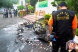 Polisi melakukan olah Tempat Kejadian Perkara (TKP) sesaat terjadi ledakan disela pemusnahan barang bukti hasil kejahatan yang dibakar di kantor Kejaksaan Negeri Makassar, Sulawesi Selatan, Rabu (11/4/2018). Kejadian tersebut melukai dua orang, dan diduga ledakan tersebut dipicu baterei ponsel yang dibakar bersamaan dengan kosmetik yang mengandung bahan kimia. (ANTARA FOTO/Darwin Fatir)