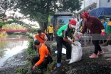 Wali Kota Surabaya Tri Rismaharini (kanan) memungut sampah di pinggiran Sungai Kalimas di Jembatan Merah, Surabaya, Jawa Timur, Jumat (27/4). Kegiatan bersih-bersih yang dilakukan oleh anggota polisi Polrestabes Surabaya, TNI AD dan Pemkot Surabaya di kawasan itu untuk menyambut HUT ke-73 Bhayangkara. Antara Jatim/Didik Suhartono/zk/18