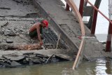 Sejumlah pekerja dengan palu, las, juga peralatan lainnya mengempur jembatan Widang di Kecamatan Widang, Tuban, Jawa Timur, Sabtu (21/1). Proses perbaikan jembatan Widang di Bengawan Solo yang menghubungkan Lamongan-Tuban itu, dengan mengganti jembatan 'bally' pada bagian yang ambruk membutuhkan waktu sekitar 1,5 bulan.  Antara Jatim/Aguk Sudarmojo/zk/18.