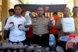 Kapolres Sukabumi AKBP Nasriadi (tengah) memperlihatkan barang bukti bahan-bahan minuman keras (miras) oplosan dan hasil racikan saat konferensi pers di Polres Sukabumi, Palabuhanratu, Sukabumi, Jawa Barat, Selasa (10/4/2018). Berdasarkan data Polres Sukabumi sebanyak 18 warga Kabupaten Sukabumi masuk rumah sakit setelah menenggak miras oplosan, tujuh di antaranya meninggal dunia. (ANTARA FOTO/Budiyanto)