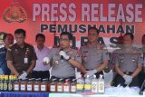 Kapolda Jatim Irjen Pol Machfud Arifin(tengah) menunjukkan barang bukti minuman keras (miras) yang berhasil disita dalam Operasi Tumpas Narkoba Semeru 2018 di Polda Jatim, Surabaya, Jawa Timur, Rabu (25/4). Sebanyak 50.070 botol miras berbagai jenis dan merk berhasil disita oleh Polda Jatim, Polrestabes Surabaya, Polres Pelabuhan Tanjung Perak Surabaya dan Polresta Sidoarjo dalam operasi yang digelar selama 10 hari tersebut. Antara Jatim/Didik Suhartono/zk/18