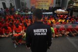 Polisi menunjukkan tersangka beserta barang bukti saat merilis hasil ungkap kasus Operasi Tumpas Narkoba Semeru 2018 di Mapolrestabes Kota Surabaya, Jawa Timur, Kamis (26/4). Polrestabes Kota Surabaya dan jajarannya dalam Operasi Tumpas Narkoba Semeru 2018 berhasil menangkap 589 tersangka dan mengamankan barang bukti diantaranya berupa sabu sebanyak 507,92 gram, pil double L atau pil koplo sebanyak 3.500.164 butir, 7 unit sepeda motor serta uang tunai sebesar Rp66.302.000. Antara Jatim/Moch Asim/zk/18