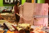 Panitia menata batik yang dipajang dalam Pameran Batik Kontemporer di Malang, Jawa Timur, Selasa (24/4). Pameran yang diadakan selama sepuluh hari tersebut bertujuan mengenalkan sekaligus membandingkan motif  batik bergaya kontemporer hasil  perpaduan corak tenun, sulam serta batik hasil karya para pengrajin dari berbagai daerah seperti Yogyakarta, Surakarta, Madura dan Malang. Antara Jatim/Ari Bowo Sucipto/zk/18.