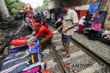 Warga melakukan transaksi jual beli di pasar kaget pinggir rel kereta di kawasan Citeureup, Bogor, Jawa Barat, Jumat (6/4). Meskipun berbahaya dan berpotensi mengakibatkan kecelakaan serta mengganggu lalu lintas kereta, para pedagang tetap menjajakan dagangannya di pasar tersebut. ANTARA JABAR/Yulius Satria Wijaya/agr/18.