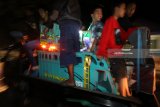 Sejumlah anak mengangkut miniatur truk berbahan baku kayu di dalam bak mobil terbuka di Desa Pojok, Kediri, Jawa Timur, Sabtu (7/4) malam. Kegiatan kumpul dan touring bareng tersebut diikuti oleh sedikitnya 250 unit miniatur truk dari daerah Kediri, Blitar, dan Malang. Antara jatim/Prasetia Fauzani/zk/18