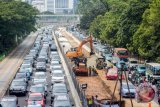 Pekerja dibantu alat berat mengerjakan proyek pembangunan trotoar di Jalan Sudirman, Jakarta, Selasa (17/4/2018). Pemprov DKI Jakarta melakukan penataan trotoar di Jalan Sudirman-MH Thamrin sepanjang 6,6 kilometer dengan konsep mengubah bentuk trotoar menjadi multifungsi dengan spot edukasi, spot budaya dan spot usaha, yang ditargetkan selesai sebelum Asian Games Agustus mendatang yang dibangun dengan total anggaran Rp180 miliar. (ANTARA FOTO/Galih Pradipta) 