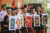 Sejumlah penari membawa lambang partai politik saat pentas kesenian dalam rangka sosialisasi Pemilu 2019 di Indramayu, Jawa Barat, Sabtu (21/4). Kegiatan yang digelar KPUD Indramayu dengan tema 