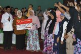 Menteri Sosial Idrus Marham (ketiga kiri) bersama Bupati Bogor Nurhayanti (tengah) menyerahkan secara simbolis kartu keluarga sejahtera kepada warga yang berhak menerima saat Penyaluran Bantuan Sosial Program Keluarga Harapan (PKH) dan Bantuan Sosial Pangan Beras Sejahtera (Bansos Rastra) di Gedung Tegar Beriman, Cibinong, Kabupaten Bogor, Jawa Barat, Jum'at (13/4). Kementerian Sosial berencana untuk menambah nominal bantuan sebagian penerima PKH pada tahun 2019 dan menambah jumlah penerima PKH dari 10 juta jiwa menjadi 15 juta jiwa se-Indonesia sebagai upaya mengurangi angka kemiskinan. ANTARA JABAR/Arif Firmansyah/agr/18