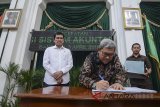 Menteri Pemberdayaan Aparatur Negara, Reformasi dan Birokrasi (Menpan RB) Asman Abnur (kiri) menyaksikan Gubernur Jawa Barat Ahmad Heryawan (kedua kiri) yang tengah menandatangani perjanjian kinerja perangkat daerah saat acara percepatan reformasi birokrasi di Aula Barat Gedung Sate, Bandung, Jawa Barat, Selasa (3/4). Percepatan reformasi birokrasi yang digalakan oleh Kemenpan RB tersebut merupkan langkah dalam mencegah program atau kegiatan siluman. ANTARA JABAR/Raisan Al Farisi/agr/18