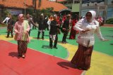 Wali Kota Surabaya Tri Rismaharini (ketiga kiri) menari Gemu Fa Mi Re bersama para murid dan guru saat berkunjung ke SMP Negeri 3 Surabaya, Jawa Timur, Sabtu (21/4). Kegiatan tersebut dalam rangka memperingati Hari Kartini. Antara Jatim/Moch Asim/zk/18