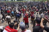 Cabup petahana Syahri Mulyo (tengah) menunjukkan ikan lele hasil tangkapannya dalam permainan tradisional gogo iwak (berebut menangkap ikan) di sebuah pematang sawah di Tulungagung, Jawa Timur, Minggu (1/4). Permainan tradisional gogo iwak itu digelar dalam rangkaian calon bupati/wakil bupati petahana dengan cara melepas lima ton ikan budidaya untuk diperebutkan bersama masyarakat. Antara Jatim/Destyan Sujarwoko/zk/18