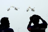 Warga mendokumentasikan atraksi Udara helikopter yang dilakukan oleh TNI AU di Pangkalan Udara Atang Sendjaja, Bogor, Jawa Barat, Sabtu (21/4). Atraksi udara tersebut merupakan rangkaian HUT TNI AU ke-72. ANTARA JABAR/Yulius Satria Wijaya/agr/18.