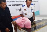 Isteri almarhum Mustofa masinis Kereta Api (KA) Sancaka yang tewas kecelakaan, Dian Kartika Utami Sari (kiri) mencium foto suaminya di prasasti usai ditandatangani Dirut PT Kereta Api Indonesia (KAI) Edi Sukmoro di ruang pertemuan PT Kereta Api Indonesia (KAI) Daerah Operasi (Daops) 7 Madiun, Jawa Timur, Rabu (11/4). Prasasti tersebut untuk mengenang Mustofa dan sebagai penghormatan kepada Mustofa yang tewas akibat KA Sancaka yang dimasinisi bertabrakan dengan truk tronton di antara Stasiun KA Kedungbanteng-Walikukun Ngawi, Jawa Timur, Jumat (6/4). Antara Jatim/Foto/Siswowidodo/zk/18