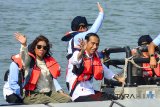 Presiden Joko Widodo (kanan) didampingi Menteri Kelautan dan Perikanan, Susi Pudjiastuti (kiri) menaiki perahu karet saat meninjau lokasi keramba ikan pada peresmian Keramba Jaring Apung atau offshore di Pelabuhan Pendaratan Ikan (PPI) Cikidang, Babakan, Kabupaten Pangandaran, Jawa Barat, Selasa, (24/4). Dalam sambutannya Jokowi menjelaskan dua per tiga atau 70 persen wilayah Indonesia adalah perairan, sehingga dengan adanya terobosan keramba jaring apung bisa menambah hasil budi daya ikan. ANTARA JABAR/Adeng Bustomi/agr/18