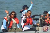 Presiden Joko Widodo (kanan) didampingi Menteri Kelautan dan Perikanan Susi Pudjiastuti (kiri) menumpang perahu karet untuk meninjau lokasi keramba ikan saat peresmian Keramba Jaring Apung atau offshore di Pelabuhan Pendaratan Ikan (PPI) Cikidang, Babakan, Kabupaten Pangandaran, Jawa Barat, Selasa (24/4/2018). Dalam sambutannya Presiden Joko Widodo menjelaskan, dua per tiga atau 70 persen wilayah Indonesia adalah perairan, sehingga dengan adanya terobosan keramba jaring apung diharapkan dapat menambah hasil budi daya ikan. (ANTARA FOTO/Adeng Bustomi) 