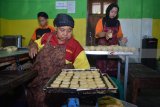 Pekerja menyelesaikan pembuatan bakpia di industri rumahan kampung pia di Gempol, Pasuruan, Jawa Timur, Jumat (20/4). Pengrajin bakpia di kampung tersebut mengaku saat ini bakpia dengan berbagai rasa yang biasa dijual dengan harga Rp 10.000 - Rp 20.000 perkotak itu mengalami kendala pemasaran akibat bersaing dengan bakpia yang diproduksi pabrik. Antara/Umarul Faruq/18