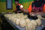 Pekerja menyelesaikan pembuatan bakpia di industri rumahan kampung pia di Gempol, Pasuruan, Jawa Timur, Jumat (20/4). Pengrajin bakpia di kampung tersebut mengaku saat ini bakpia dengan berbagai rasa yang biasa dijual dengan harga Rp 10.000 - Rp 20.000 perkotak itu mengalami kendala pemasaran akibat bersaing dengan bakpia yang diproduksi pabrik. Antara/Umarul Faruq/18