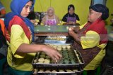 Pekerja menyelesaikan pembuatan bakpia di industri rumahan kampung pia di Gempol, Pasuruan, Jawa Timur, Jumat (20/4). Pengrajin bakpia di kampung tersebut mengaku saat ini bakpia dengan berbagai rasa yang biasa dijual dengan harga Rp 10.000 - Rp 20.000 perkotak itu mengalami kendala pemasaran akibat bersaing dengan bakpia yang diproduksi pabrik. Antara/Umarul Faruq/18