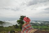 Salah satu wisatawan menikmati panorama alam berupa hamparan awan putih dari puncak Gunung Jambu di Desa Haruyan Seberang Kecamatan Haruyan Kabupaten Hulu Sungai Tengah (HST), Minggu  (1/4) . Menuju lokasi  sangat mudah dari kota Barabai sekitar 12 kilometer dan bisa menggunakan kendaraan roda 2 atau 4.  Gunung Jambu yang menyimpan sejuta keindahan alam yang begitu indah  saat  sore dan cuaca cerah bisa menikmati sunset  yang  indah dan sangat menawan tenggelam diantara awan-awan. Dari puncaknya dengan mudah melihat hamparan pegunungan Meratus dan kota Barabai dengan barisan awan putih yang berjejer.Foto: Antaranews Kalsel/Taupik Rahman/F.
