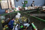 Sejumlah pekerja memilah sampah non organik dan barang bekas beracun (B3) pada mesin konveyor di Pusat Daur Ulang Sampah Jambangan, Surabaya, JawaTimur, Sabtu (14/4). Pusat Daur Ulang tersebut mengolah tiga hingga lima ton sampah pada satu hari tersebut 40 persen merupakan sampah organik sisa dapur diproses menjadi kompos dan 20 persen non organik di jual pada pengepul. Antara Jatim/M Risyal Hidayat/zk/18
