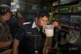 Petugas Satpol PP Bandung memeriksa minuman beralkohol saat menggelar razia di Bandung, Jawa Barat, Rabu (11/4). Razia tersebut dilakukan guna mencegah peredaran minuman keras (miras) oplosan yang telah menyebabkan puluhan korban meninggal sepanjang beberapa waktu terakhir. ANTARA JABAR/Novrian Arbi/agr/18
