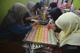 Pekerja menyelesaikan makanan kue kering atau kue karakter di Kampung Pamijahan, Tasikmalaya, Jawa Barat, Kamis (12/4). Kementerian Perindustrian mencatat sumbangan industri makanan dan minuman terhadap produk domestik bruto (PDB) industri nonmigas mencapai 34,95 persen pada triwulan ketiga 2017, dengan perkembangan realisasi investasi sektor industri makanan dan minuman untuk penanaman modal dalam negeri mencapai Rp27,92 triliun atau meningkat 16,3 persen, sedangkan penanaman modal asing mencapai 1,46 miliar Dollar Amerika Serikat. ANTARA JABAR/Adeng Bustomi/agr/18