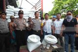 Kapolres Jember AKBP Kusworo Wibowo (tengah) menunjukkan barang bukti yang digunakan pelaku pencurian gula di sebuah garasi truk yang berada di Jalan Otista, Kabupaten Jember, Jawa Timur, Selasa (24/4) sore. Polres Jember menangkap lima orang yang diduga menjadi sindikat pencuri gula saat menjalankan aksinya mengurangi gula dalam kemasan karung di sebuah garasi truk. Antarajatim/Zumrotun Solichah/zk/18