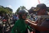 Kapolres Blitar Kota AKBP Adewira Negara Siregar (Kanan) memasangkan tali helm kepada seorang peserta ibu-ibu yang bersiap untuk berkendara bersama saat kampanye keselamatan berkendara bagi ibu-ibu di halaman depan Mapolres Blitar Kota, Jawa Timur, Selasa (17/4). Selain meperingati hari kartini, kampanye keselamatan tersebut juga bertujuan untuk menekan angka korban kecelakaan dari kalangan ibu-ibu dan perempuan. Antara Jatim/Irfan Anshori/zk/18