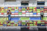 Warga mengecat tembok dengan ragam bendera negara dari Benua Asia dan Afrika di Sekolah Rakyat Ibu Inggit Garnasih, Bandung, Jawa Barat, Sabtu (14/4). Pengecatan 109 bendera peserta Konferensi Asia Afrika (KAA) yang mengusung tema toleransi independen tersebut dilakukan untuk memperingati KAA yang jatuh pada tanggal 18 April mendatang. ANTARA JABAR/Raisan Al Farisi/agr/18