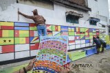 Warga mengecat tembok dengan ragam bendera negara dari Benua Asia dan Afrika di Sekolah Rakyat Ibu Inggit Garnasih, Bandung, Jawa Barat, Sabtu (14/4). Pengecatan 109 bendera peserta Konferensi Asia Afrika (KAA) yang mengusung tema toleransi independen tersebut dilakukan untuk memperingati KAA yang jatuh pada tanggal 18 April mendatang. ANTARA JABAR/Raisan Al Farisi/agr/18