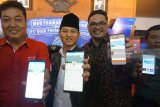 Plt Bupati Trenggalek Moch Nur Arifin (tengah) didampingi Director PT Qlue Performa Indonesia Dedi Irawan Sinuhaji (kiri)  dan Community Partnership Ibrahim Ukrin (kanan) menunjukkan aplikasi Qlue di ponselnya usai peluncuran program ujicoba aplikasi Qlue di Pendopo Trenggalek, Jawa Timur, Kamis (12/4). Aplikasi Qlue yang didesain untuk meningkatkan layanan publik berbasis android ini diujicoba pemerintah daerah setempat untuk memudahkan masyarakat melaporkan segala permasalahan berkaitan dengan layanan masyarakat, mulai dari administrasi kependudukan, kesehatan, pendidikan hingga infrastruktur dan kebencanaan. Antara Jatim/Destyan Sujarwoko/zk/18