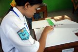 Siswa penyadang tuna netra mengerjakan soal Ujian Nasional Berbasis Kertas dan Pensil (UNBKP) di SLB Budi Mulia Blitar, Jawa Timur, Selasa (10/4). Guna mempermudah pengawasan dan pelaksanaan ujian, sebanyak lima siswa berkebutuhan khusus dari tiga sekolah didaerah tersebut melaksanakan UNBKP disatu lokasi sekolah.Antara Jatim/Irfan Anshori/zk/18