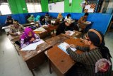 Sejumlah pelajar berbusana adat tradisional saat mengikuti Ujian Sekolah Berstandar Nasional (USBN) di SMP Muhammadiyah 11 Surabaya, Jawa Timur, Sabtu (21/4/2018). Hal itu dalam rangka memperingati Hari Kartini. (ANTARA FOTO/Didik Suhartono)