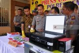 Kapolres Jember AKBP Kusworo Wibowo (ketiga kiri), Kasir Senior Bank Indonesia Jember Joni Setiyahadi (kedua kiri), memperlihatkan uang palsu saat rilis di Mapolres Jember, Jawa Timur, Selasa (17/4). Polres Jember mengamankan warga Kabupaten Lumajang, Sukamim karena membuat dan mengedarkan uang palsu (upal) antar kabupaten dengan barang bukti mesin cetak/printer, 101 lembar uang pecahan Rp20.000 palsu, 25 lembar kertas fotocopy pecahan Rp20.000 yang belum dipotong, dan pengungkapan ini sekaligus mengantisipasi peredaran upal menjelang Pilkada dan Ramadan. Antara Jatim/Seno/zk/18.