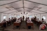 Sejumlah siswa SMP korban gempa bumi, mengikuti Ujian Nasional Kertas dan Pensil (UNKP) di tenda darurat milik Kemendikbud, di SMP N 2 Kalibening, Banjarnegara, Jawa Tengah, Senin (23/4/2018). Sebanyak 60 siswa SMP N 2 Kalibening kelas 9, terpaksa mengikuti Ujian Nasional di tenda darurat, akibat sebagian ruang kelas dan bangunan sekolah mereka rusak dan ambruk, akibat gempa bumi. (ANTARA FOTO/Idhad Zakaria) 